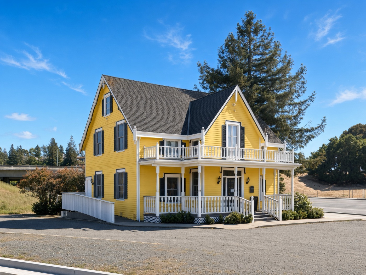 The yellow Victorian office building in Castro Valley with a white porch and balcony